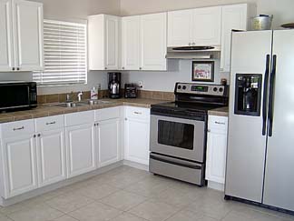 A more modern look with bright white<br />thermal foil raised panel doors.<br />Same cabinet boxes were used.<br />Just a very nice refacing job.