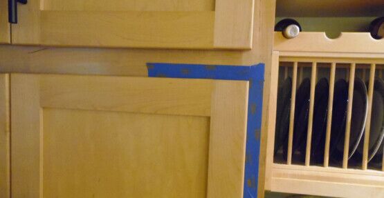 Using blue painters tape to measure your cabinet door overlay